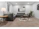 Comfortable living room features a sectional sofa, large artwork, and plush carpet at 9378 E 60Th Pl, Denver, CO 80238