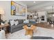 Cozy living room with a comfortable gray sofa, wood table, and open flow to the kitchen at 9378 E 60Th Pl, Denver, CO 80238