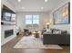 Modern living room with a fireplace, large window, comfortable seating, and artistic decor at 9378 E 60Th Pl, Denver, CO 80238