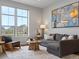 Bright living room with large windows, a gray sofa, and view of the neighborhood at 9378 E 60Th Pl, Denver, CO 80238