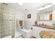 Bright bathroom featuring a glass block shower and a vanity with granite countertops and a skylight at 2222-2224 Hooker St, Denver, CO 80211