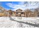 Inviting brick home with a dormer and chimney is surrounded by snow and bushes during the winter season at 2222-2224 Hooker St, Denver, CO 80211
