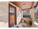 Covered brick front porch with wood accents and a light fixture at 2222-2224 Hooker St, Denver, CO 80211