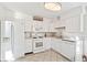 Bright white kitchen featuring appliances, tile flooring, and white cabinetry at 2222-2224 Hooker St, Denver, CO 80211