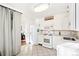 Bright white kitchen with gas range, tile flooring, and an open doorway to another room at 2222-2224 Hooker St, Denver, CO 80211