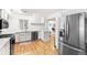 Bright kitchen with stainless steel appliances, light hardwood floors, and white cabinets at 2222-2224 Hooker St, Denver, CO 80211