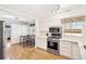 A bright kitchen featuring white cabinets, stainless steel appliances, and light hardwood floors at 2222-2224 Hooker St, Denver, CO 80211