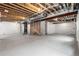Unfinished basement with concrete floor, exposed ceiling, and structural supports at 8903 Springsong Ln, Littleton, CO 80125