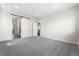 Spacious bedroom with neutral carpeting and sliding barn door to bathroom at 8903 Springsong Ln, Littleton, CO 80125