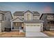 Charming two-story home with gray siding, a two-car garage, and a well-manicured front yard at 8903 Springsong Ln, Littleton, CO 80125
