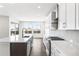 Modern kitchen featuring a gas range, stainless steel appliances, an island and sleek white cabinets at 8903 Springsong Ln, Littleton, CO 80125