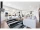 Open concept living room features neutral furniture, large windows, and flows into the kitchen at 8903 Springsong Ln, Littleton, CO 80125