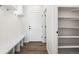 Functional mudroom with built-in bench, coat hooks, adjacent to the pantry, and wooden floors at 8903 Springsong Ln, Littleton, CO 80125