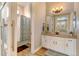 Bright bathroom featuring a shower with a patterned curtain and a modern vanity with ample storage at 8000 Gore Creek Ln, Littleton, CO 80125