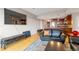 Cozy living room with a leather sofa, wood floors, and a view of the kitchen area at 2990 E 17Th Ave # 1102, Denver, CO 80206