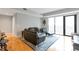 Cozy living room with wood flooring, a leather sofa, and sliding glass doors to the balcony at 2990 E 17Th Ave # 1102, Denver, CO 80206