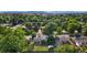 A high angle shows homes nestled within lush green trees with a grass lawn and mountain view in the distance at 216 Hemlock, Broomfield, CO 80020