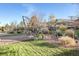 Landscaped backyard with stone patio, mature trees, grass and an attractive decorative water feature at 8796 E 150Th Ct, Thornton, CO 80602