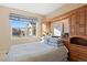 Comfortable bedroom with built-in wooden cabinetry, a cozy bed, and a bright window with neighborhood views at 8796 E 150Th Ct, Thornton, CO 80602