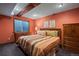 Cozy bedroom with a colorful striped comforter, window, and wood beam at 8796 E 150Th Ct, Thornton, CO 80602