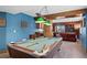 Basement billiards room with a pool table, wet bar, and pool ball storage with view to Gathering room at 8796 E 150Th Ct, Thornton, CO 80602