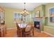 Dining room features a fireplace, a chandelier, and ample natural light from large windows at 8796 E 150Th Ct, Thornton, CO 80602