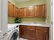 Well-lit laundry room with wooden cabinets, ample counter space, a sink, and a front-loading washing machine at 8796 E 150Th Ct, Thornton, CO 80602