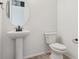 Clean half-bathroom featuring a pedestal sink, toilet, and modern fixtures at 8205 Cokedale Cir, Littleton, CO 80125
