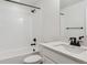 Well-lit bathroom with white tiling around the tub/shower, a white vanity, and sleek black hardware at 8205 Cokedale Cir, Littleton, CO 80125