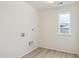Efficient laundry room with wood-look flooring, hookups, and a window offering natural light at 8205 Cokedale Cir, Littleton, CO 80125