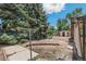 Backyard features mature trees and a storage shed surrounded by brick edging, enhancing the property's outdoor space at 1680 S Patton Ct, Denver, CO 80219