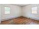 Bright bedroom featuring hardwood floors, two windows allowing natural light, and neutral walls creating a serene atmosphere at 1680 S Patton Ct, Denver, CO 80219
