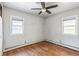 Bright bedroom featuring hardwood floors, two windows allowing natural light, and a ceiling fan, creating a comfortable atmosphere at 1680 S Patton Ct, Denver, CO 80219