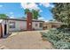 Exterior view of the home showcasing the siding, chimney, and gravel landscaping, providing a tidy outdoor space at 1680 S Patton Ct, Denver, CO 80219