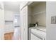 Hallway featuring hardwood floors, white walls, a sliding door opening to a laundry room with washer and dryer at 1680 S Patton Ct, Denver, CO 80219