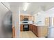 Traditional kitchen featuring wooden cabinets, black appliances, and an island with a sink, perfect for cooking and gathering at 1680 S Patton Ct, Denver, CO 80219