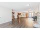 Open-concept living room featuring hardwood floors, large windows, ceiling fan, and wood burning stove fireplace at 1680 S Patton Ct, Denver, CO 80219