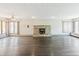 Bright and airy living room with hardwood floors, large windows, ceiling fan, and wood burning stove fireplace at 1680 S Patton Ct, Denver, CO 80219