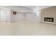 Spacious basement featuring modern fireplace, brick wall, and light laminate floors at 310 S Alkire St, Lakewood, CO 80228
