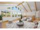Bright living room with vaulted ceilings, exposed beams, and expansive windows offering natural light at 310 S Alkire St, Lakewood, CO 80228