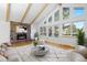 Cozy living room featuring a stone fireplace, vaulted ceilings, and a wall of windows for abundant light at 310 S Alkire St, Lakewood, CO 80228