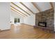 Spacious living room with a stone fireplace, exposed beams, and a sliding door to the backyard and pool at 310 S Alkire St, Lakewood, CO 80228