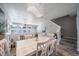 Bright dining area features a stylish chandelier, with an open view of the living space and stairs at 12069 Monaco Ct, Brighton, CO 80602