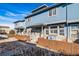 Charming blue townhomes feature stone accents, a quaint fence, and well-maintained landscaping at 12069 Monaco Ct, Brighton, CO 80602