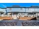 Exterior view of townhomes with blue siding, stone accents, and wood fences at 12069 Monaco Ct, Brighton, CO 80602