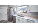 Bright kitchen features stainless steel appliances, double basin sink, and white cabinetry at 12069 Monaco Ct, Brighton, CO 80602