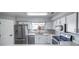 Modern kitchen with stainless steel appliances, white cabinets, and a bright window overlooking the neighborhood at 12069 Monaco Ct, Brighton, CO 80602