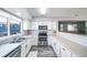 Open kitchen featuring white cabinets, a stainless steel stove and a view of the dining room at 12069 Monaco Ct, Brighton, CO 80602
