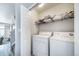 Efficient laundry room featuring a washer, dryer, and overhead shelving for organized storage and easy access at 12069 Monaco Ct, Brighton, CO 80602
