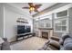 Living room area features fireplace, television, fan, and windows with lots of light at 12069 Monaco Ct, Brighton, CO 80602